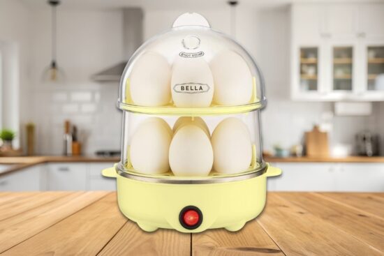 BELLA Rapid Electric Egg Cooker and Omelet Maker in yellow on a kitchen counter, filled with eggs in a double-stacked tray design.