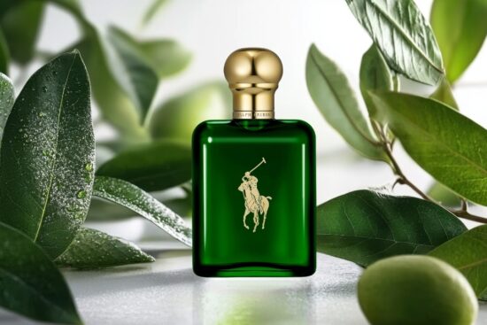 Ralph Lauren Polo Green Eau de Toilette bottle with deep green glass and gold cap, surrounded by fresh green leaves, highlighting the classic masculine fragrance design.