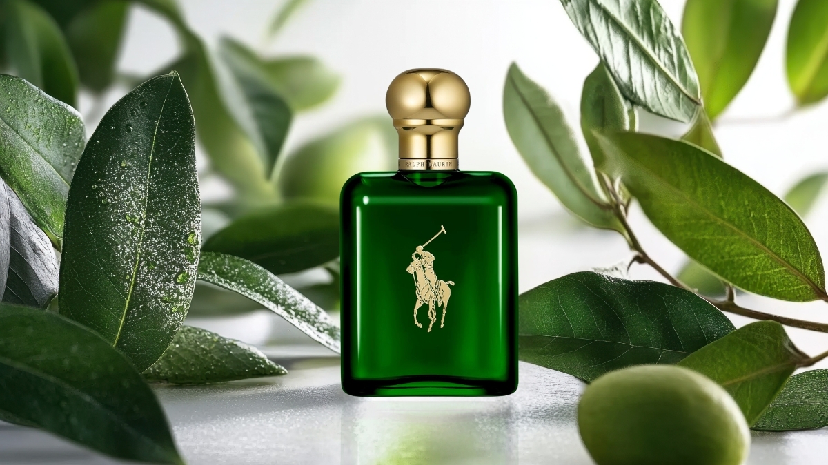 Ralph Lauren Polo Green Eau de Toilette bottle with deep green glass and gold cap, surrounded by fresh green leaves, highlighting the classic masculine fragrance design.