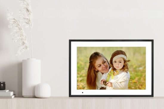 Anna Bella Digital Photo Frame displaying a clear family photo on a modern tabletop frame with a slim black bezel in a bright home setting