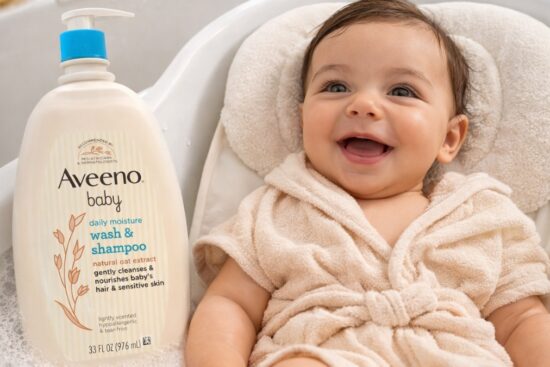 Smiling baby during bath time next to Aveeno Baby Daily Moisture Body Wash & Shampoo with natural oat extract in a pump bottle
